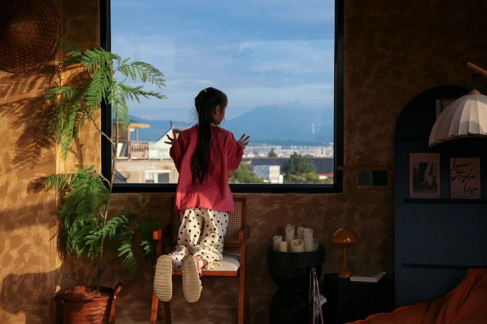 Woman looking out window at mountains and sky
